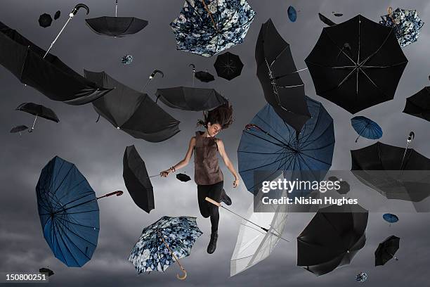 woman in the sky with umbrellas raining - white and black women and umbrella fotografías e imágenes de stock