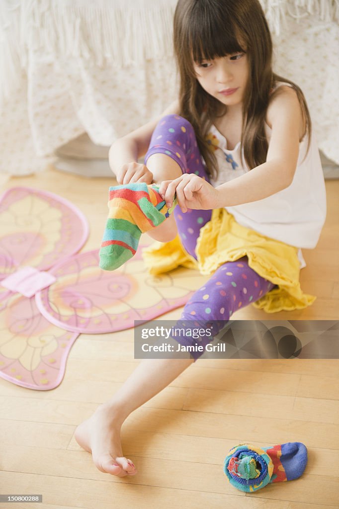Girl putting on colorful socks