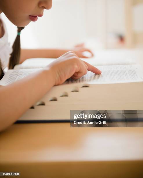 girl looking up word in dictionary - woordenboek stockfoto's en -beelden