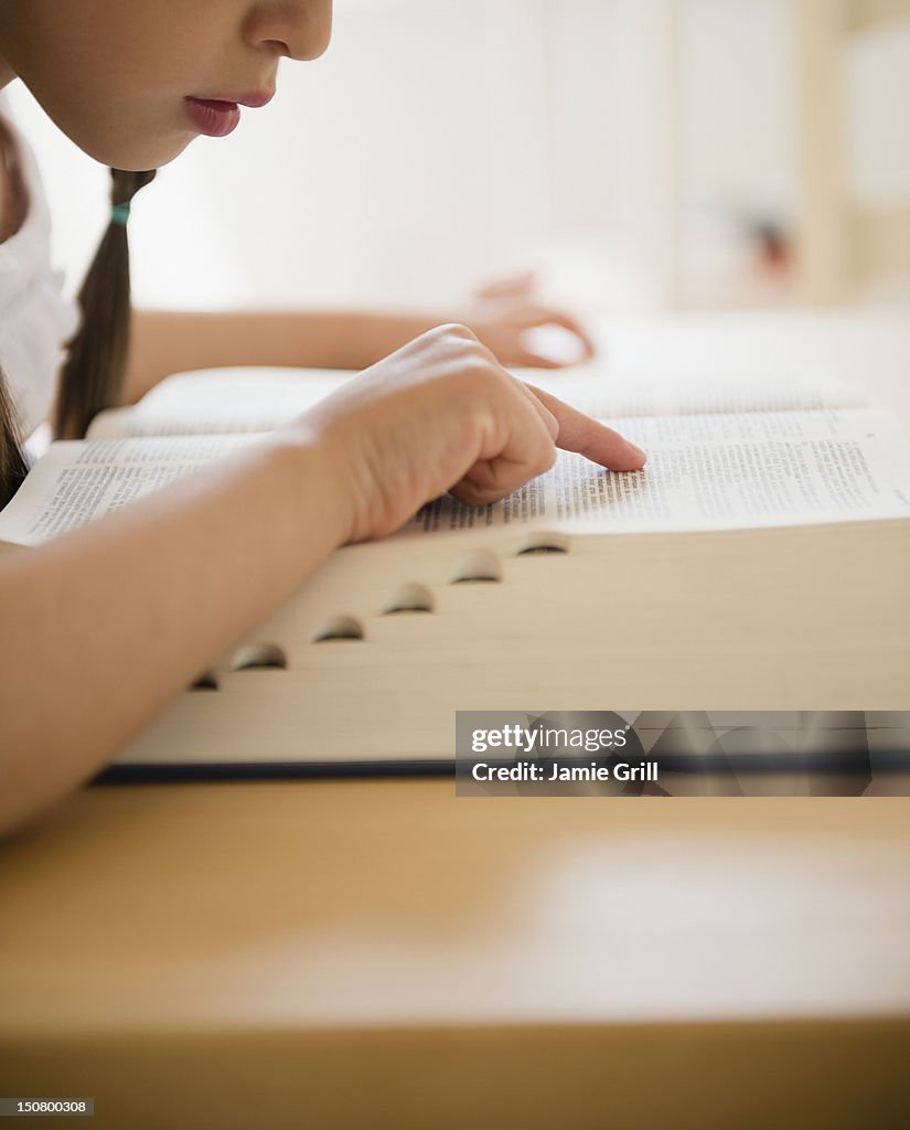Girl looking up word in dictionary
