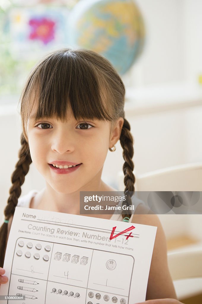 Girl holding up school work