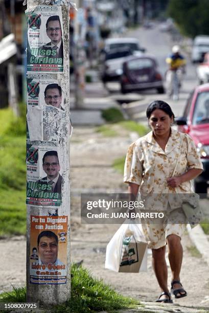 Una mujer pasa junto a carteles del candidato municipal Ulises Córdova, del Partido Verde Ecologista de México, en San Cristóbal, al sureste de...