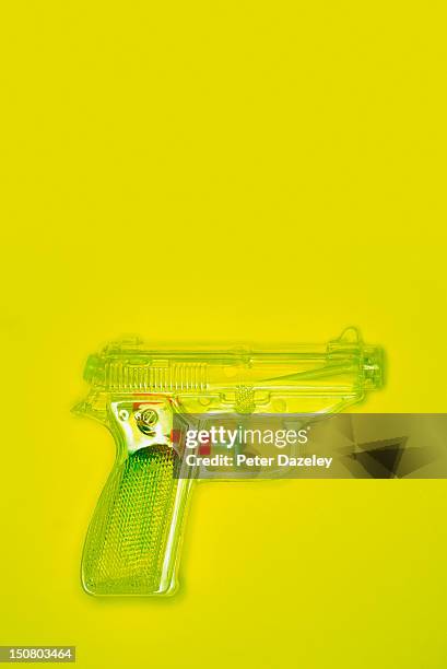 water pistol on a yellow background - toy gun stock pictures, royalty-free photos & images