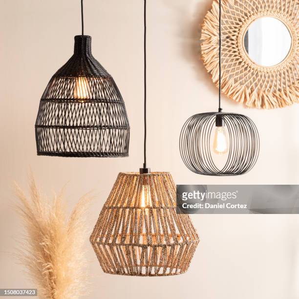 rattan style lighting fixtures hang on wall near decorative pieces - wicker photos et images de collection