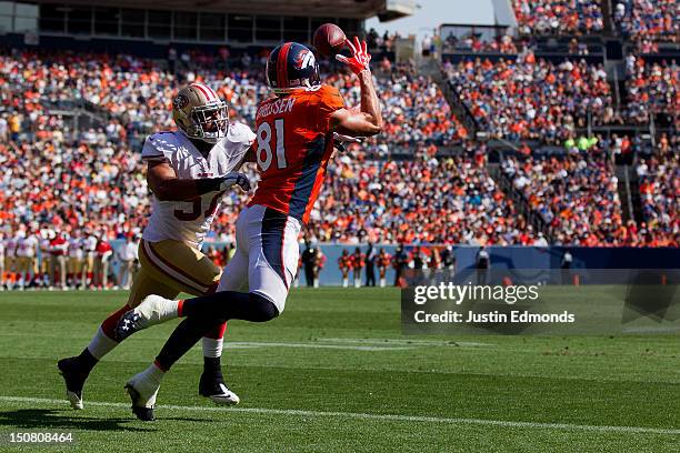 Tight end Joel Dreessen of the Denver Broncos makes a catch for a 5-yard touchdown as linebacker Michael Wilhoite of the San Francisco 49ers defends...