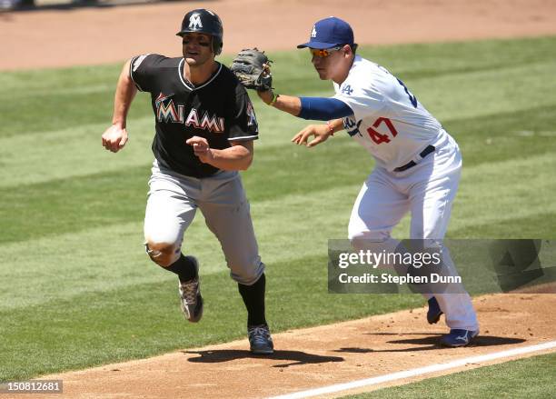 Third baseman Luis Cruz of the Los Angeles Dodgers tags out Justin Ruggiano of the Miami Marlins in a rundown between third and home in the first...