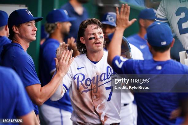 Bobby Witt Jr. #7 of the Kansas City Royals celebrates with teammates in the dugout after scoring during the first inning against the Los Angeles...