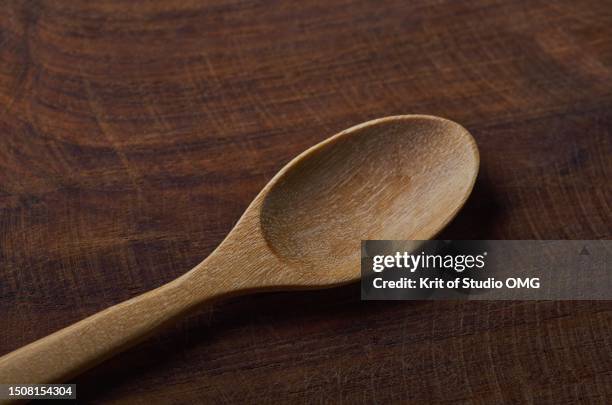 a wooden spoon on wooden table - wooden spoon stock pictures, royalty-free photos & images