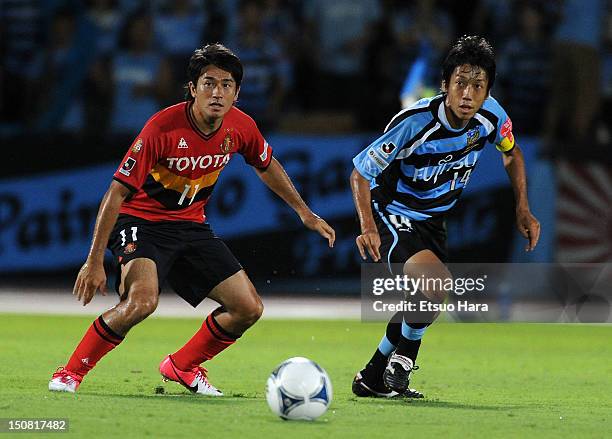 Keiji Tamada of Nagoya Grampus and Kengo Nakamura of Kawasaki Frontale compete for the ball during the J.League match between Kawasaki Frontale and...