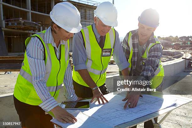 builders and architect looking at plans together - construction worker office people stock pictures, royalty-free photos & images