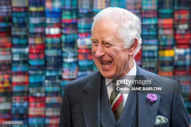 Britain's King Charles III laughs during a visit to the Lochcarron of Scotland tartan weaving mill in Selkirk, south of Edinburgh, on July 6, 2023.