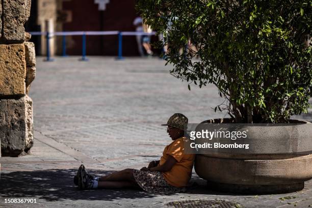 Pedestrian rests in the shade of a plant during high temperatures in the cathedral district of Seville, Spain, on Wednesday, July 5, 2023. Global...