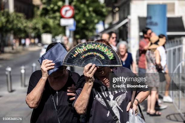 Woman use a fan to shield from the sun during high temperatures in Seville, Spain, on Thursday, July 6, 2023. Global temperatures hit a record on...