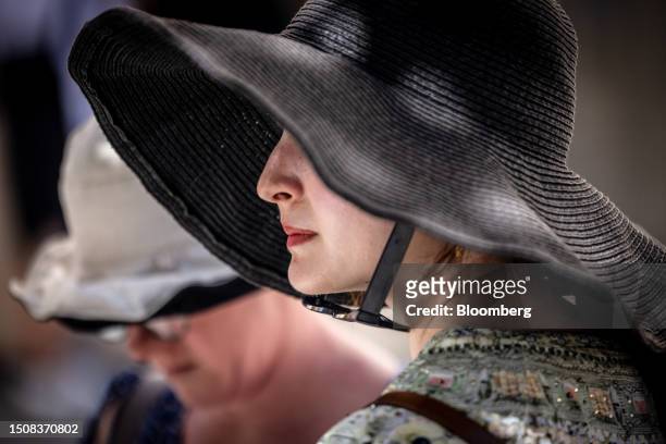 Visitor wears a wide brimmed sun hat during high temperatures in the Old Town district of Seville, Spain, on Thursday, July 6, 2023. Global...