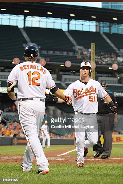 Lew Ford of the Baltimore Orioles celebrates a solo home run in the second inning with Mark Reynolds during a baseball game against the Chicago White...