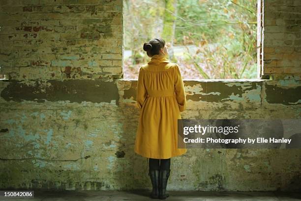 woman standing in front of brick wall - elle women stock pictures, royalty-free photos & images