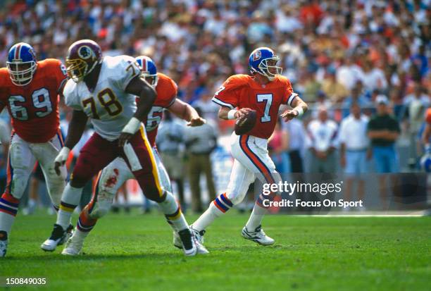 Quarterback John Elway of the Denver Broncos scrambles away from the rush against the Washington Redskins during an NFL football game September 17,...