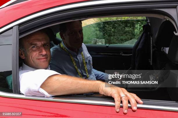 French President Emmanuel Macron rides in the organisation vehicle with Tour the France director Christian Prudhomme on the Col du Tourmalet during...