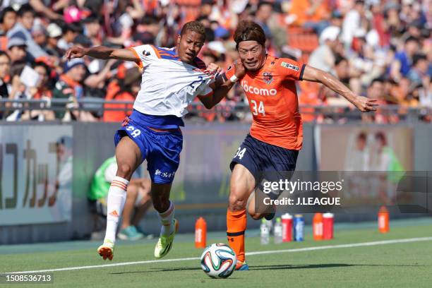 Musashi Suzuki of Albirex Niigata and Yosuke Kataoka of Omiya Ardija compete for the ball during the J.League Yamazaki Nabisco Cup Group B match...