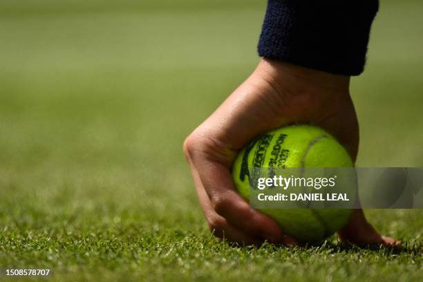 Ball boy holds an official tennis ball in his hands during the men's singles tennis match between Germany's Alexander Zverev and Netherlands' Gijs...