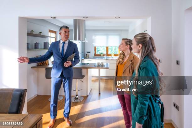 real estate agent showing lesbian couple apartment - real estate showing stock pictures, royalty-free photos & images