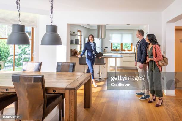 female real estate agent showing couple apartment - selling house stockfoto's en -beelden