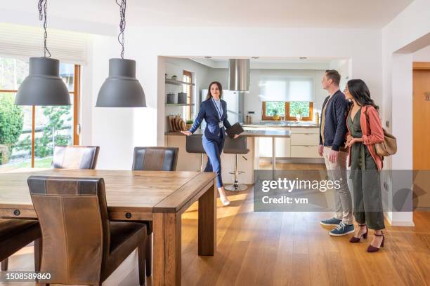 female real estate agent showing couple apartment - realtor stock pictures, royalty-free photos & images