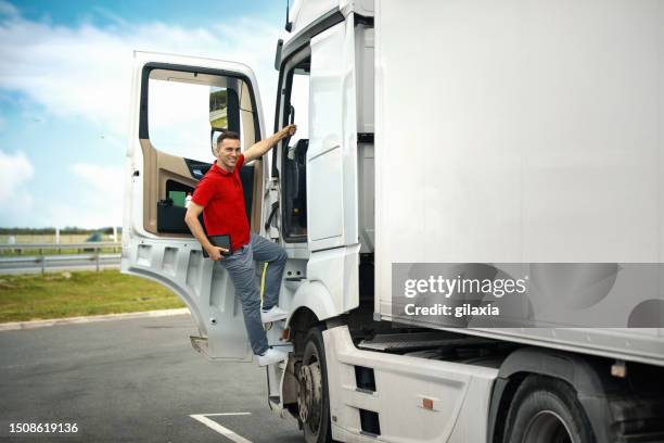 lkw-fahrer auf einem parkplatz, der in die kabine einsteigt. - einsteigen stock-fotos und bilder