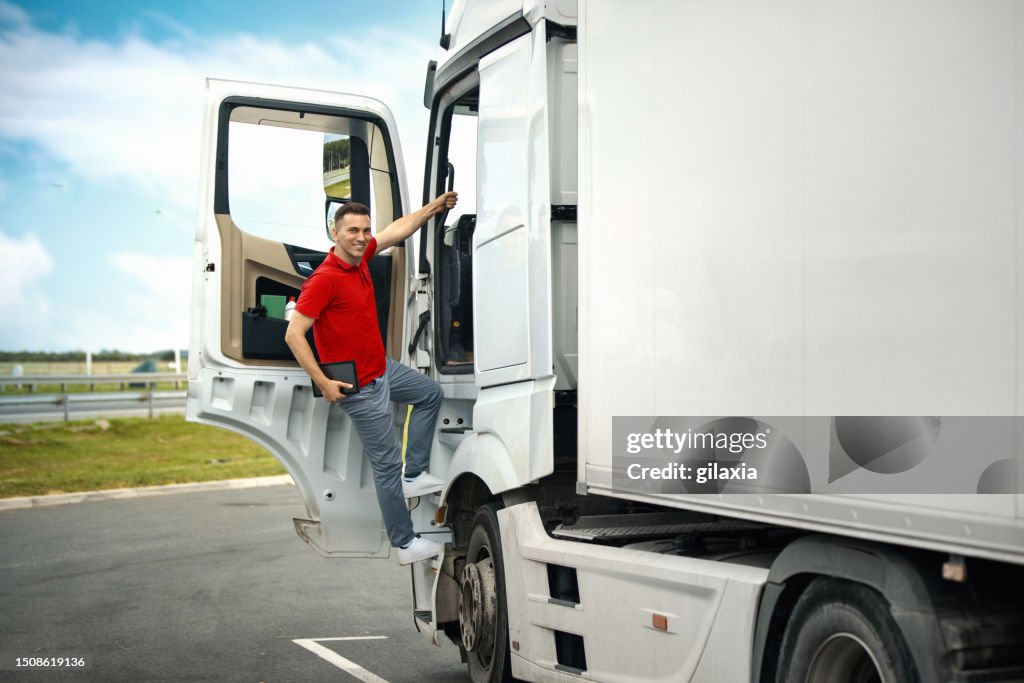 Truck driver at a parking lot getting into the cabin.