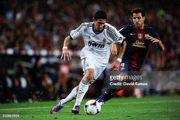 Angel Di Maria of Real Madrid CF duels for the ball with Cesc Fabregas of FC Barcelona during the Super Cup first leg match between FC Barcelona and...