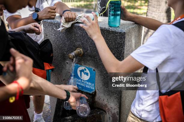 Visitors replenish their water supplies from a fountain on Puerta de Jerez square during high temperatures in Seville, Spain, on Wednesday, July 5,...