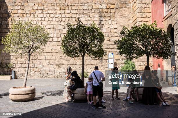 Pedestrians wait in the shade during high temperatures near the cathedral in Seville, Spain, on Wednesday, July 5, 2023. Global temperatures hit a...