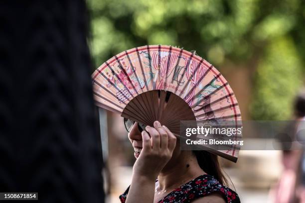 Woman uses a fan during high temperatures in Seville, Spain, on Wednesday, July 5, 2023. Global temperatures hit a record on Monday, underscoring the...