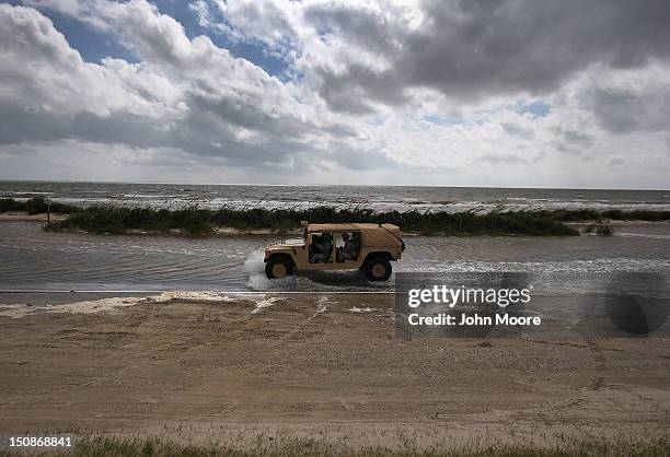 National Guard patrol passes along a flooded beach ahead of the arrival of Hurricane Isaac on August 28, 2012 in Waveland, Mississippi. Many...