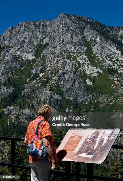 Visitor stops to read a sign at a scenic roadside stop overlooking Emerald Bay on August 8 in South Lake Tahoe, California. Lake Tahoe, straddling...