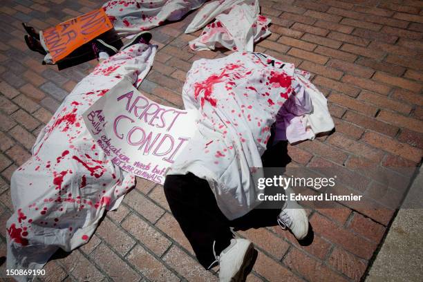 Several protesters from Code Pink lay under sheets to bring attention to the casualties of foreign conflicts outside the Straz Center for the...