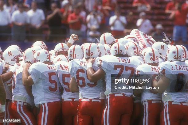 Nebraska Cornhuskers huddle before a college football game against the West Virginia Mountaineers on August 31, 1994 at Giants Stadium in East...