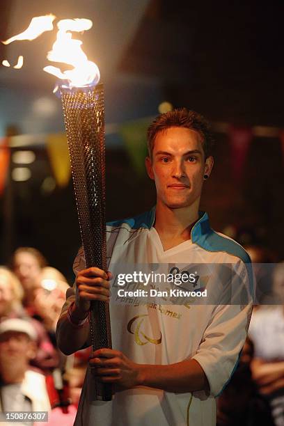 Torchbearers exchange the Paralympic flame outside Stoke Mandeville Spinal Unit on August 28, 2012 in Stoke Mandeville, England. The Stoke Mandeville...