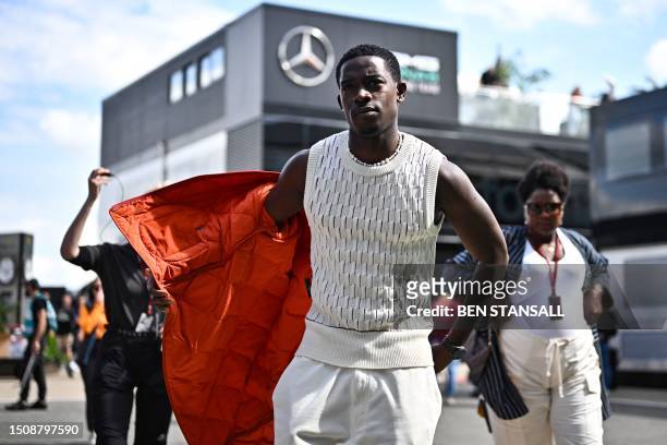 British actor Damson Idris, the co-star of US actor Brad Pitt in an F1-inspired movie, walks in the paddock ahead of the Formula One British Grand...