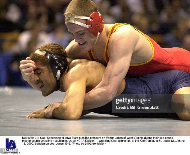 Cael Sanderson of Iowa State puts the pressure on Vertus Jones of West Virginia during their 184 pound championship wrestling match in the 2000 NCAA...