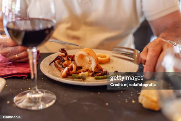 eating squid in oil. typical dish of andalusian culture, almeria. spain - almeria restaurant stock-fotos und bilder