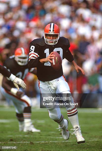 Quarterback Bernie Kosar of the Cleveland Brown runs with the ball against the Washington Redskins during an NFL football game at RFK Stadium October...