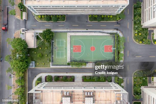 greening and enclosed basketball court in industrial area - grüner gürtel sport stock-fotos und bilder