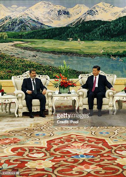 Egyptian President Mohamed Morsi chats with Chinese Vice-President Xi Jinping during their meeting in the Great Hall of the People on August 29, 2012...