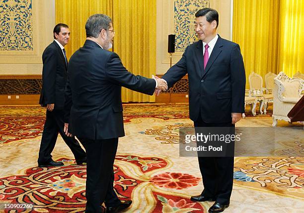 Egyptian President Mohamed Morsi shakes hands with Chinese Vice-President Xi Jinping during their meeting in the Great Hall of the People on August...