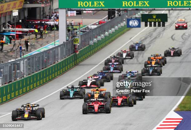 Max Verstappen of the Netherlands driving the Oracle Red Bull Racing RB19 leads Charles Leclerc of Monaco driving the Ferrari SF-23 and the rest of...