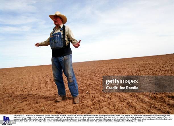 Lane Goar, a farmer of 40 years, stands in a field that should have a crop of winter wheat but is nothing but dirt near Clovis, N.M., March 21, 2000....