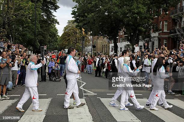 Paralympic Torchbearers Ken Maidens, Graham Helm, Ketaki Vaidya and Lucy Priest carry Paralympic torches across the Abbey Road pedestrian crossing,...