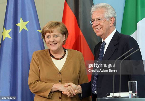 Italian Prime Minister Mario Monti shakes hands with German Chancellor Angela Merkel after a news conference at the German federal Chancellory on...