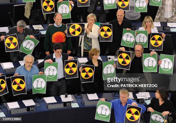 Co Presidents of the Greens/European Free Alliance group, Daniel Cohn Bendit and Rebecca Harms hold placards with crossed nuclear signs and wind...